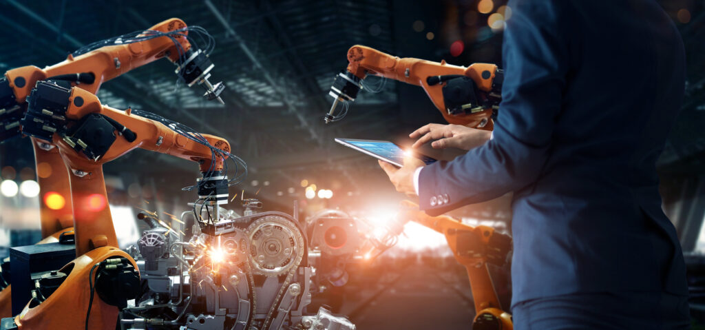 Manager engineer check and control automation robot arms machine in intelligent factory industrial on real time monitoring system software. Welding robotics and digital manufacturing operation.